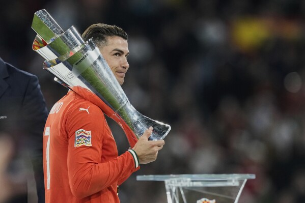 Portugal's Cristiano Ronaldo holds the trophy after winning the Nations League final soccer match between Portugal and Spain at the Allianz Arena in Munich, Germany, Monday, June 9, 2025. (AP Photo/Martin Meissner)