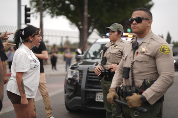 Protesters confront law enforcement agents outside an industrial park in Paramount section of Los Angeles on Saturday, June 7, 2025 (AP Photo/Eric Thayer)