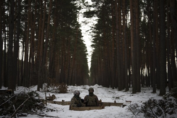 Ukrainian servicemen stand at a position close to the border with Belarus, Ukraine, Wednesday, Feb. 1, 2023. (AP Photo/Daniel Cole)