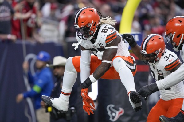 Cleveland Browns tight end David Njoku (85) leaps as he celebrates scoring a touchdown during the first half of an NFL football game against the Houston Texans, Sunday, Dec. 24, 2023, in Houston. (AP Photo/David J. Phillip)