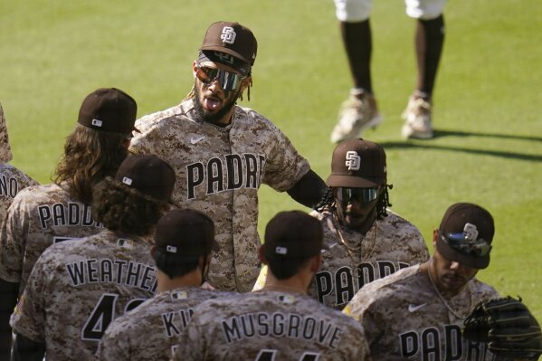 San Diego Padres shortstop Fernando Tatis Jr, top left, celebrates with teammates after they defeated the Los Angeles Dodgers in a baseball game Sunday, April 18, 2021, in San Diego. (AP Photo/Gregory Bull)