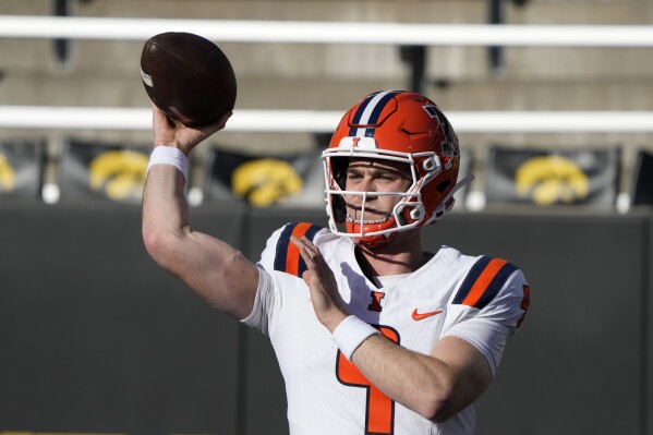 Illinois quarterback Luke Altmyer warms up before an NCAA college football game against Iowa, Saturday, Nov. 18, 2023, in Iowa City, Iowa. (AP Photo/Charlie Neibergall)