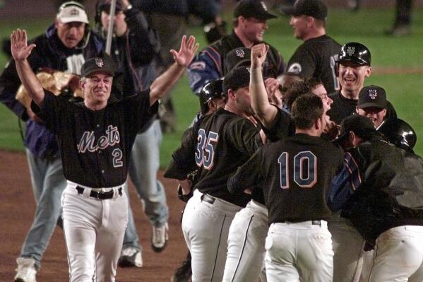 FILE - New York Mets manager Bobby Valentine (2) throws his arms up as his team celebrates on the field after Mets' Robin Ventura's grand slam-turned single in the 15th inning to defeat the Atlanta Braves 4-3 in Game 5 of the NL Championship Series in New York, in this Sunday, Oct. 17, 1999, file photo. For the Mets, July 30 will be a dark day — in a good way. New York will use black jerseys for the first time since 2012 when the Mets play Cincinnati at Citi Field that night. The Mets said Thursday, July 15, 2021, that they will use black jerseys for all remaining Friday night home games this season. (AP Photo/Chris Gardner, File)