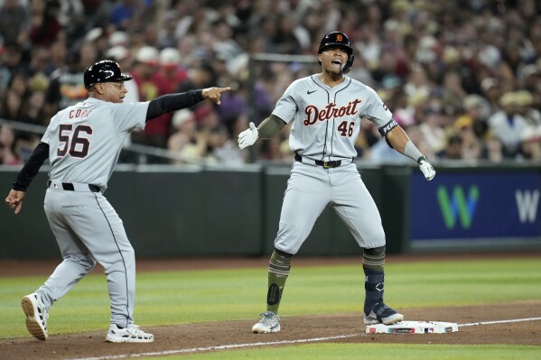 Detroit Tigers' Wenceel Pérez (46) celebrates his three-run triple against the Arizona Diamondbacks as Tigers third base coach Joey Cora (56) points to the baseball during the seventh inning of a baseball game Saturday, May 18, 2024, in Phoenix. (AP Photo/Ross D. Franklin)