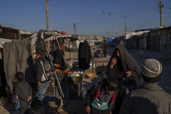 people stroll through the marketplace in the al-hol detention camp in northeastern syria's hassakeh province, where tens of thousands of mostly women and children linked to the islamic state group have been living for years, thursday, jan. 30, 2025. (ap photo/bernat armangue)