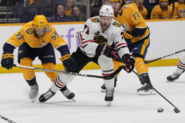 Chicago Blackhawks left wing Taylor Hall, right, moves the puck past Nashville Predators defenseman Roman Josi (59) during the first period of an NHL hockey game Saturday, Nov. 18, 2023, in Nashville, Tenn. (AP Photo/George Walker IV)