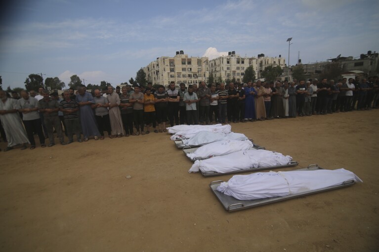 FILE - Mourners pray by the bodies of al-Agha family members who were killed during an Israeli airstrike, during their funeral in Khan Younis, Gaza Strip, Wednesday, Oct. 11, 2023. Mohanad al-Agha was killed along with his wife, two toddler daughters, father and mother and four of his six brothers in an Israeli airstrike on Oct. 11. (AP Photo/Hatem Ali, File)