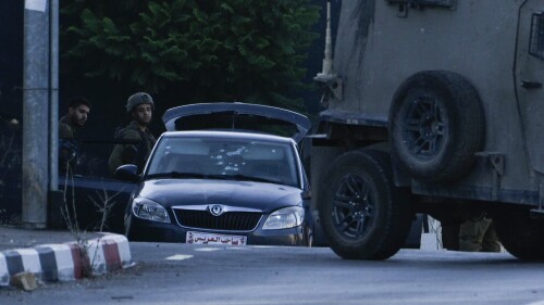 Israeli soldiers stand by a car used by three alleged Palestinian gunmen after they were killed in Nablus, West Bank, on Tuesday, July 25, 2023. Israeli security forces said they opened fire at Palestinian militants who had shot at them from a car, while Palestinian media described the Israeli killing of the gunmen as an ambush following the militants' attempted attack on Israeli forces near a Jewish settlement overlooking Nablus. (AP Photo/Majdi Mohammed)