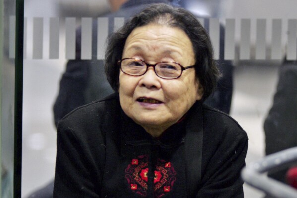 FILE - AIDS activist Gao Yaojie checks in to a ticket counter at the Beijing Capital airport as she prepares to leave China for the U.S. in Beijing, China, Monday, Feb. 26, 2007. Gao, a Chinese doctor who embarrassed the government by exposing the AIDS epidemic in rural China in the 1990s and spent her last decade in exile in the United States, died Sunday, Dec. 10, 2023, at her home in Manhattan. She was 95. (AP Photo/Elizabeth Dalziel, File)