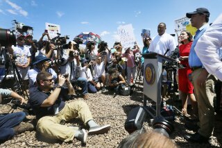 U.S. Rep. Alexandria Ocasio-Cortez, D-New York, talks about what she saw on her tour of area border facilities Monday, July 1, at the Border Patrol station in Clint. Ocasio-Cortez was attempting to talk over the protesters. (Briana Sanchez / El Paso Times via AP)