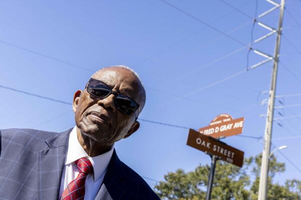 Fred Gray poses with the street renamed in his honor at the Fred D. Gray Avenue dedication ceremony, Tuesday, Oct. 26, 2021, in Montgomery, Ala. The civil-rights attorney was honored with his name on the road previously known as W. Jeff Davis Avenue. (AP Photo/Vasha Hunt)