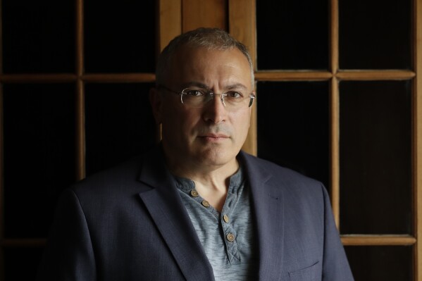FILE - Russian opposition figure Mikhail Khodorkovsky, the former owner of the Yukos Oil Co., poses for a photo after being interviewed by The Associated Press in London, Tuesday, July 24, 2018. After President Vladimir Putin came to power in 2000, he was reported to have told about two dozen of the men regarded as Russia's top oligarchs that if they stayed out of politics, their wealth wouldn't be touched. Khodorkovsky, regarded as Russia's richest man at the time, established the Open Society reformist group and showing increased political ambitions. But he was arrested in 2003 and spent a decade in prison on convictions of tax evasion and embezzlement before Putin pardoned him and he left Russia. (AP Photo/Matt Dunham, File)