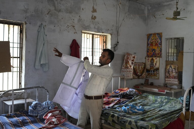 Jitendra Kumar, a paramedic, gets ready for duty in a room he shares with several others at the district government hospital quarters, in Banpur in the Indian state of Uttar Pradesh, Sunday, June 18, 2023. Ambulance drivers and other healthcare workers in rural India are the first line of care for those affected by extreme heat. (AP Photo/Rajesh Kumar Singh)