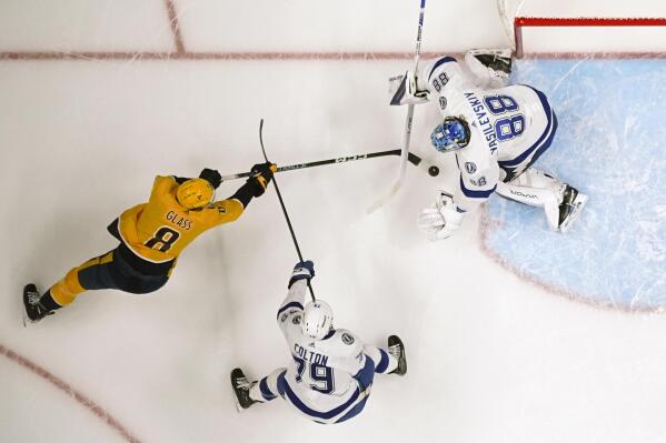 Tampa Bay Lightning goaltender Andrei Vasilevskiy (88) blocks the puck as Nashville Predators' Cody Glass (8) closes in during the first period of an NHL hockey game Saturday, Nov. 19, 2022, in Nashville, Tenn. (AP Photo/Mark Humphrey)