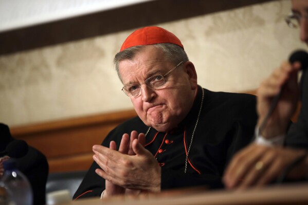 FILE - Cardinal Raymond Burke applauds during a news conference at the Italian Senate, in Rome, on Sept. 6, 2018. Pope Francis has taken measures to punish one of his highest-ranking critics, Cardinal Raymond Burke, by yanking his right to a Vatican apartment and salary in the second such radical action against a conservative American prelate this month, according to two people briefed on the measures. (AP Photo/Alessandra Tarantino, File)