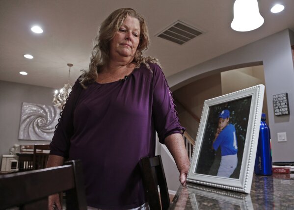 
              Shana Muse looks at a framed picture of her youngest son as she talks about the custody battle for her children against Word of Faith Fellowship church leaders, during an interview in Charlotte, N.C. on Sept. 26, 2017. Muse was persuaded to join Word of Faith Fellowship by her two sisters, who said their church could help her: She had a drug problem and was facing legal problems in Florida for writing bad checks. After moving to Spindale, N.C., she said she reached a breaking point when she saw her children and others being screamed at and beaten in the name of God. (AP Photo/Chuck Burton)
            