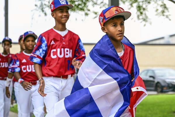 This photo provided by Caleb Craig shows Alfredo Despaigne leading his Cuban teammates as they arrive at Penn College for the Little League World Series picnic in Williamsport, Pa., Monday, Aug. 14, 2023. They’ve been hosting a Little League World Series around here since 1947, but they’ll be welcoming a new guest when the tournament starts Wednesday – Cuba. (Caleb Craig via AP)