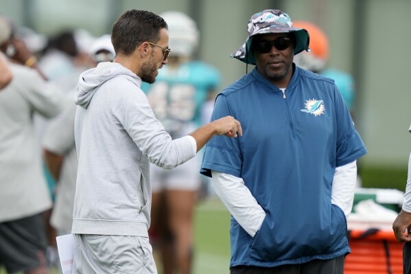 Miami Dolphins head coach Mike McDaniel, left, talks with general manager Chris Grier, right, during practice at the NFL football team's training facility, Tuesday, Aug. 1, 2023, in Miami Gardens, Fla. (AP Photo/Lynne Sladky)