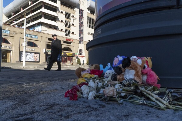 Flowers and toys lie on the ground at a makeshift memorial commemorating victims of a Dec. 30 missile attack by Ukraine in Belgorod, Russia, Monday, Feb. 19, 2024. Belgorod has come under repeated Ukrainian shelling, and hundreds of bus stops in the city near the border with Ukraine have been reinforced with blocks of concrete and sandbags to protect them from rocket strikes. (AP Photo/Kirill Zarubin)