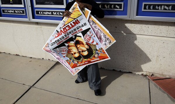 
              FILE - In this Dec. 17, 2014, file photo, a poster for the movie "The Interview" is carried away by a worker after being pulled from a display case at a Carmike Cinemas movie theater in Atlanta. A computer programmer working for the North Korean government was charged with devastating cyberattacks that hacked Sony Pictures Entertainment and unleashed the WannaCry ransomware virus that infected computers in 150 countries and crippled parts of the British health care system, federal prosecutors said Thursday, Sept. 6, 2018. U.S. officials believe the Sony hack was retribution for "The Interview," a comedy starring Seth Rogen and James Franco in a plot to assassinate North Korea's leader, Kim Jong Un. (AP Photo/David Goldman, File)
            