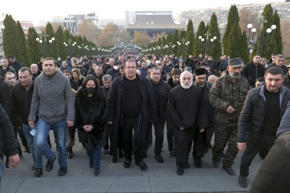 Demonstrators attend a rally demanding the resignation of the country's prime minister over his handling of the conflict with Azerbaijan over Nagorno-Karabakh in Yerevan, Armenia, Saturday, Dec. 19, 2020. Both opponents and supporters of Armenia's prime minister rallied Saturday as the nation paid tribute to the thousands who died in fighting with Azerbaijan over the region of Nagorno-Karabakh. The loss of lands that had been controlled by ethnic Armenian forces for more than a quarter-century has traumatized Armenians, triggering weeks of protests demanding the resignation of Prime Minister Nikol Pashinyan. (Hrant Khachatryan/PAN Photo via AP)