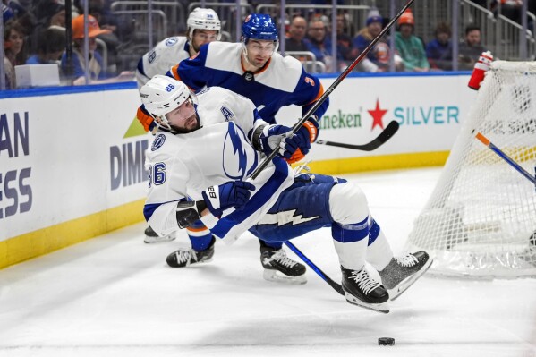 Tampa Bay Lightning's Nikita Kucherov (86) falls down while battling for control of the puck with New York Islanders' Adam Pelech (3) during the first period of an NHL hockey game Saturday, Feb. 24, 2024, in Elmont, N.Y. (AP Photo/Frank Franklin II)