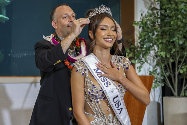 In this image provided by the Office of Governor Josh Green, Hawaii Gov. Josh Green crowns Savannah Gankiewicz Miss USA 2023 on Wednesday, May 15, 2024, in Honolulu. Gankiewicz was crowned on Wednesday, more than a week after the previous titleholder resigned citing her mental health. (Office of Governor Josh Green, M.D. via AP)