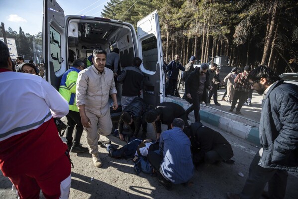 ADDS SOURCE - Injured people get aid after an explosion in Kerman, Iran, Wednesday, Jan. 3, 2024. Iran says the deadly twin bomb blasts occurred at an event honoring a prominent Iranian general slain in a U.S. airstrike in 2020. (Mahdi Karbakhsh Ravari/Mehr News Agnecy via AP)