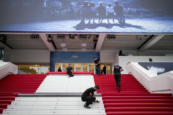 Festival workers lay the red carpet at the Palais des Festivals on opening day of the 77th international film festival, Cannes, southern France, Tuesday, May 14, 2024. The Cannes film festival runs from May 14 until May 25, 2024. (Photo by Andreea Alexandru/Invision/AP)