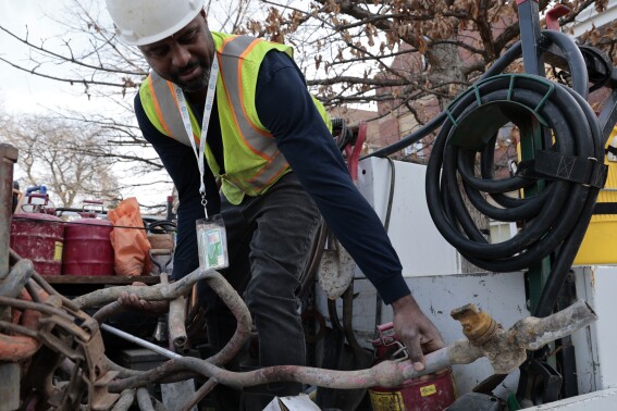 FILE - Blackhawk Sewer & Water contractor Khaild Waarith holds a lead pipe that was extracted in Chicago on April 10, 2023. The Environmental Protection Agency did not verify estimates of lead pipes before distributing $3 billion in funding for lead pipe replacement in 2023, likely meaning some states got too much and others got too little, according to the agency’s inspector general. (Antonio Perez/Chicago Tribune via AP)