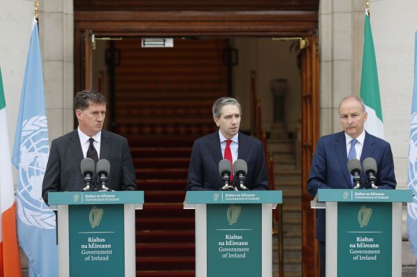 Three Irish government leaders, from left, Minister Eamonn Ryan, Minister Simon Harris, and Minister Tánaiste Michael Martin speak to the media on Wednesday, May 22, 2024, in Dublin, Ireland.  (Damien Storan/PA via AP)