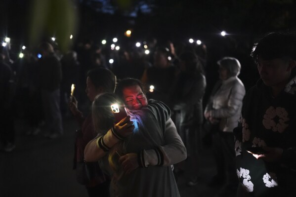 Liza Ahyeng, center right, hugs another attendee at a vigil for victims after a vehicle drove into a crowd during a Filipino heritage festival in Vancouver, British Columbia, Sunday, April 27, 2025. (AP Photo/Lindsey Wasson)