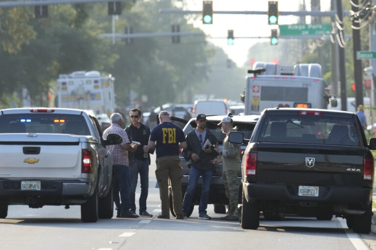 FILE - Law enforcement officials investigate the scene of a mass shooting at a Dollar General store, Saturday, Aug. 26, 2023, in Jacksonville, Fla. (AP Photo/John Raoux, File)