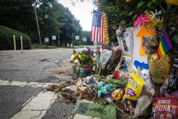 A makeshift memorial to Katherine Janness is seen at the entrance to Piedmont Park on Sunday, Aug. 1, 2021, in Atlanta. Janness, 40, was found stabbed to death in the park in the early hours of July 28.   Police say her dog was also killed at the scene. No arrests have been made and the FBI is assisting local authorities in the case. (AP Photo/Ron Harris)