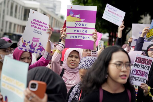 Activists display posters during an International Women's Day rally in Jakarta, Indonesia, Friday, March 8, 2024. (AP Photo/Dita Alangkara)