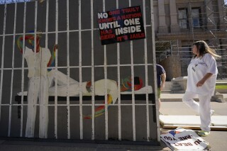ARCHIVO - Activistas que apoyan la instalación de aire acondicionado en prisiones de Texas levantan un escenario relacionado con el calor en las cárceles antes de una manifestación afuera del Capitolio en Austin, Texas, el 18 de julio de 2023. (AP Foto/Eric Gay, Archivo)