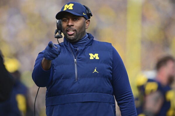 Michigan acting coach Sherrone Moore reacts to a video replay during the first half of the team's NCAA college football game against Ohio State, Nov. 25, 2023, in Ann Arbor, Mich. Michigan hired Moore on Friday, Jan. 26, 2024, to replace coach Jim Harbaugh, giving the 37-year-old offensive coordinator an opportunity to lead college football's winningest program. The school made the move two days after Harbaugh bolted to lead the Los Angeles Chargers. (AP Photo/David Dermer, File)