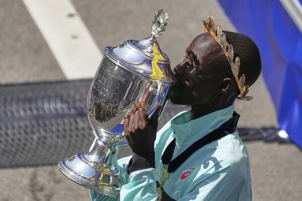 Boston Marathon winner John Korir, of Kenya, kisses the trophy while celebrating after the race, Monday, April 21, 2025, in Boston. (AP Photo/Charles Krupa)