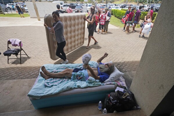 FILE - Thomas Leonard lies on an air mattress at an evacuation center at the War Memorial Gymnasium after his Lahaina apartment burned down, Thursday, Aug. 10, 2023, in Wailuku, Hawaii. Sherrie Esquivel, of Dunn, N.C., spent frantic days trying to find her father, Leonard, after fires devastated Lahaina this week. Neighbors told her early Friday, Aug. 11, he was safe, and she only found out ordeals of how he survived by reading an Associated Press article. (AP Photo/Rick Bowmer, File)