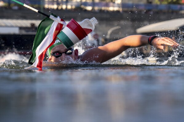A Hungarian flag marks the sports drink designated for Hungary's Kristof Rasovszky as he enters the feeding station, during the men's 10km, marathon swimming, at the 2024 Summer Olympics, Friday, Aug. 9, 2024, in Paris, France. (AP Photo/David Goldman, Pool)