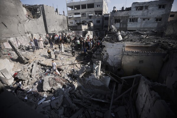 Palästinenser betrachten die Zerstörung nach dem israelischen Bombenanschlag auf das Flüchtlingslager Khan Yunis im Gazastreifen am Freitag, dem 1. Dezember 2023. (AP Photo/Mohammed Dahman)