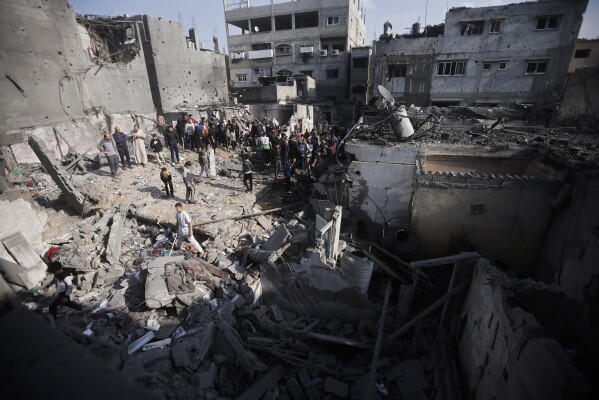 Palästinenser betrachten die Zerstörung nach dem israelischen Bombenangriff auf das Flüchtlingslager Khan Yunis im Gazastreifen am Freitag, dem 1. Dezember 2023. (AP Photo/Mohammed Dahman)