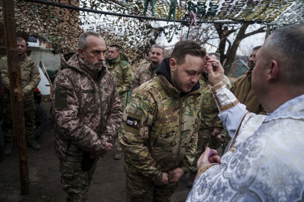 Military chaplain Yurii of 24th Mechanized Brigade blesses Ukrainian servicemen during Christmas near the frontline town of Chasiv Yar, Donetsk region, Ukraine, Wednesday Dec. 25, 2024. (AP Photo/Evgeniy Maloletka)