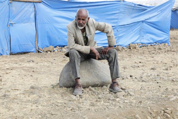 Haile Tsege, 76, sits on a rock in the Sebacare internally displaced persons (IDPs) camp, on the outskirts of Mekele, Tigray region, Ethiopia, Wednesday, Feb. 12, 2025. (AP Photo/Alexander Mamo)