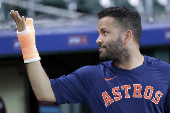 Houston Astros' Jose Altuve shows his cast to fans, reminding them why he can't sign autographs, during batting practice before a baseball game against the Detroit Tigers, Monday, April 3, 2023, in Houston. (AP Photo/Michael Wyke)
