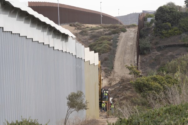 Construction crews replace sections of one of two border walls separating Mexico from the United States, Wednesday, Jan. 22, 2025, in Tijuana, Mexico. (AP Photo/Gregory Bull, File)