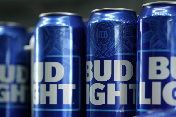 FILE - Cans of Bud Light beer are seen before a baseball game between the Philadelphia Phillies and the Seattle Mariners on April 25, 2023, in Philadelphia. Anheuser-Busch InBev has reported a drop in U.S. revenue in the second quarter as Bud Light sales plunged amid conservative backlash over a campaign with transgender influencer Dylan Mulvaney. (AP Photo/Matt Slocum, File)