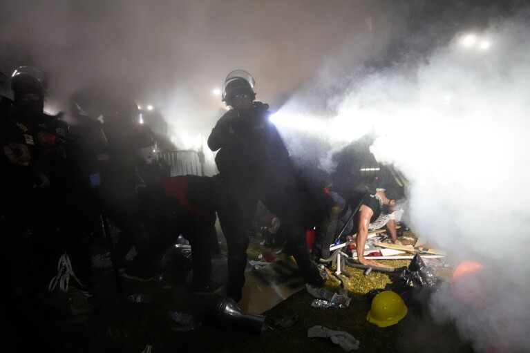 Police enter an encampment set up by pro-Palestinian demonstrators on the UCLA campus Thursday, May 2, 2024, in Los Angeles. (AP Photo/Jae C. Hong)