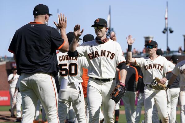 San Francisco Giants' Austin Slater, middle, celebrates with teammates after the Giants defeated the San Diego Padres in a baseball game in San Francisco, Saturday, May 8, 2021. (AP Photo/Jeff Chiu)