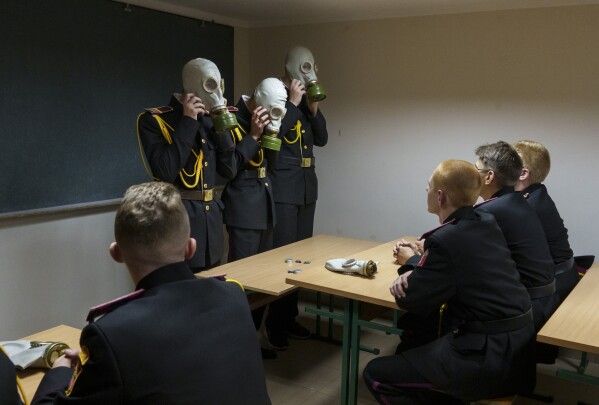 Cadets practice with gas masks during a lesson in a bomb shelter on the first day of school at a cadet lyceum in Kyiv, Ukraine, on Sept. 1, 2022. (AP Photo/ Efrem Lukatsky)